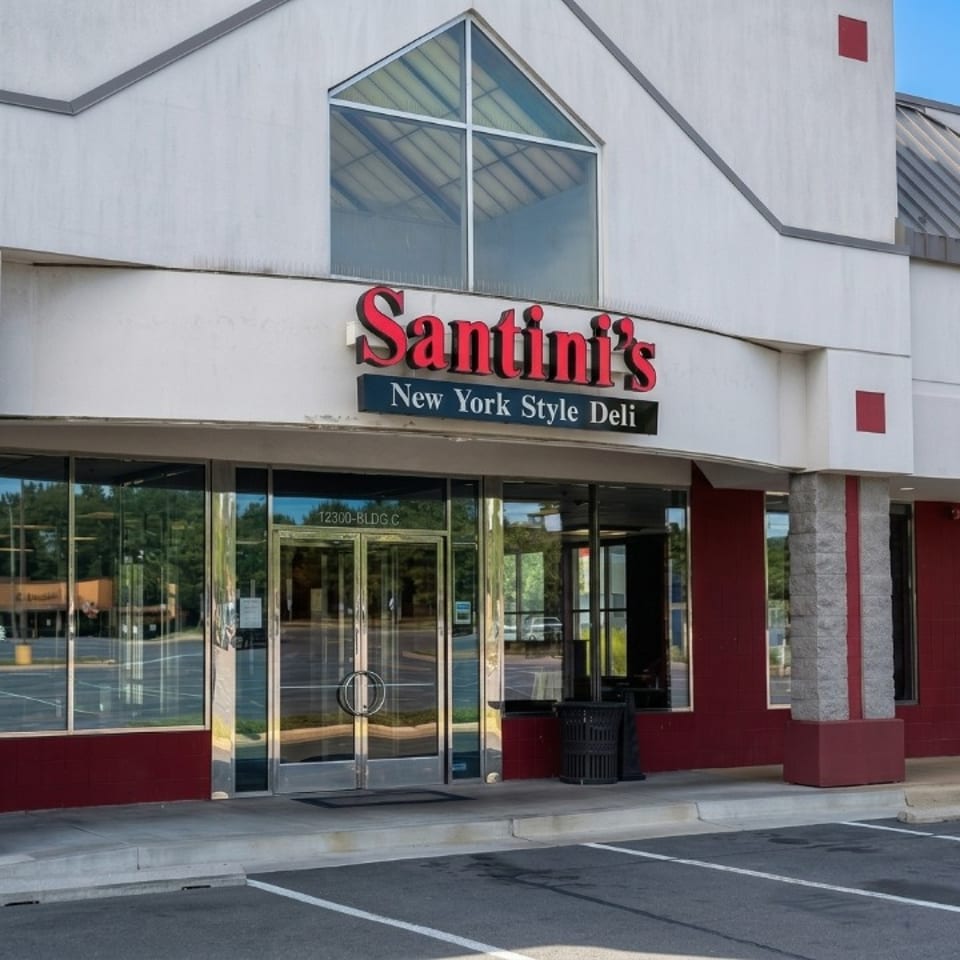 Exterior view of Santini's New York Style Deli storefront with large windows and red accents.