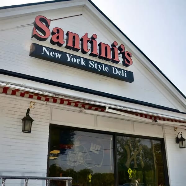 Santini's New York Style Deli sign on a white building with a red and white striped awning.